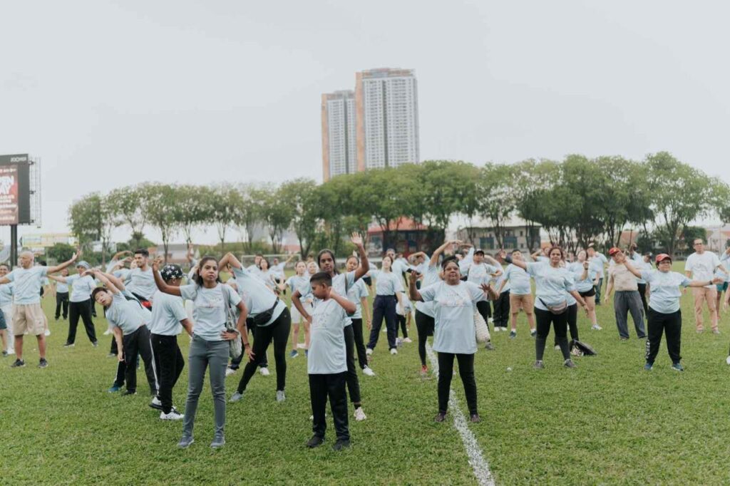 A group of people doing warm up on a field during Walk For Autism