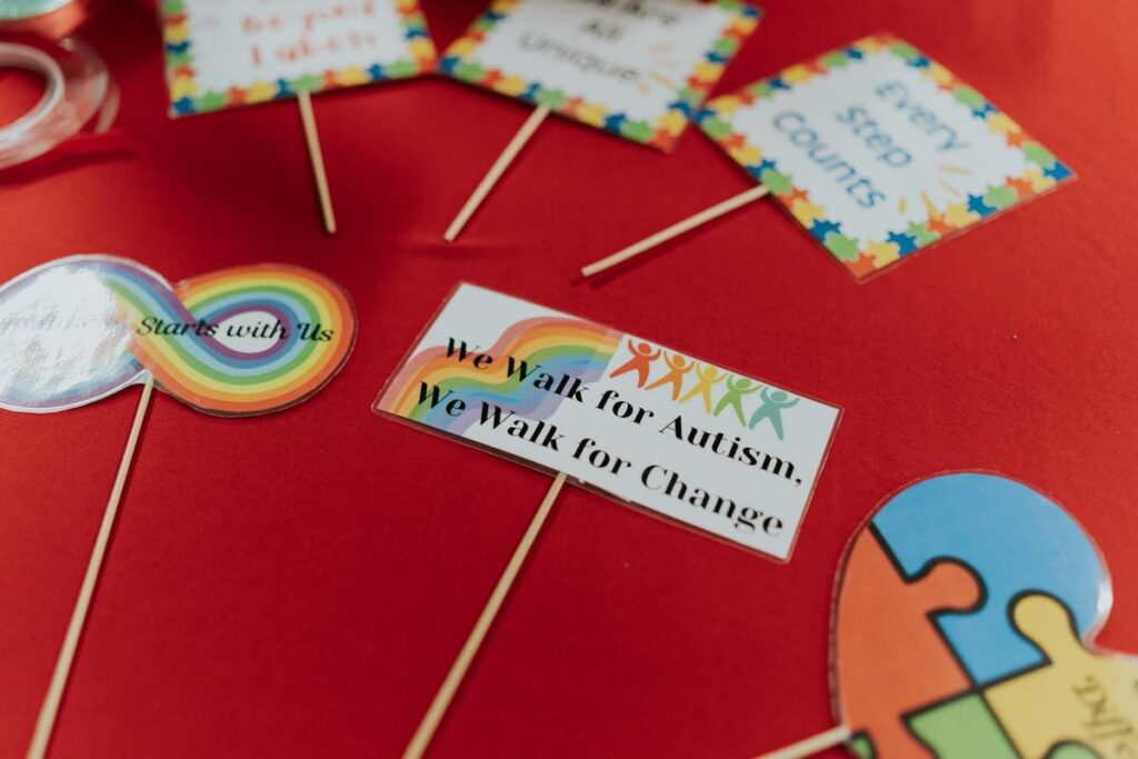 Colorful place cards with autism awareness messages displayed on a red table
