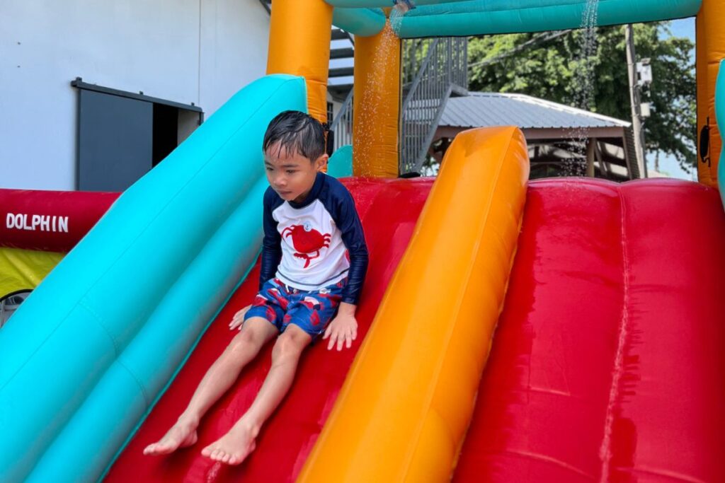 A kid sliding down the slide during Sensory Day
