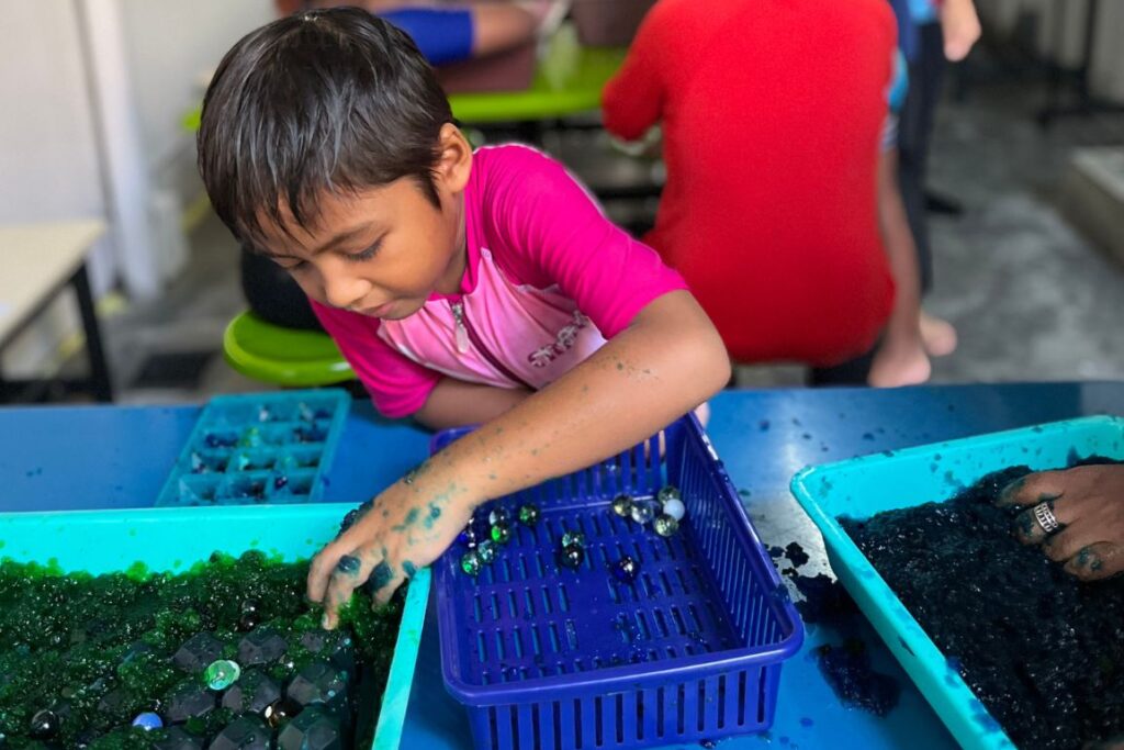 A kid finds a marble inside a jelly bowl